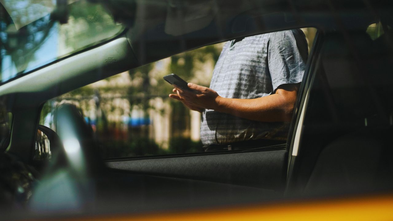 A man stands outside a second-hand car to ponder its price