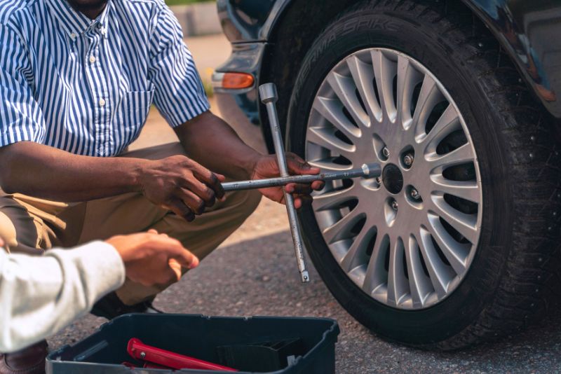 car servicing, man screwing a tyre