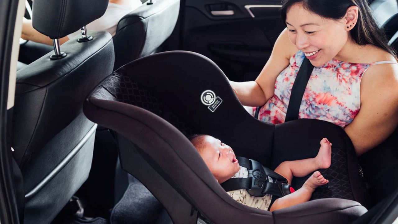 mother taking care of baby In car (booster seat)